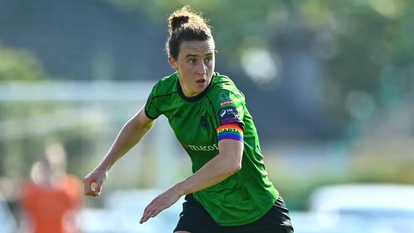 Joueuse en maillot vert courant sur le terrain Joueuse en maillot vert courant sur le terrain