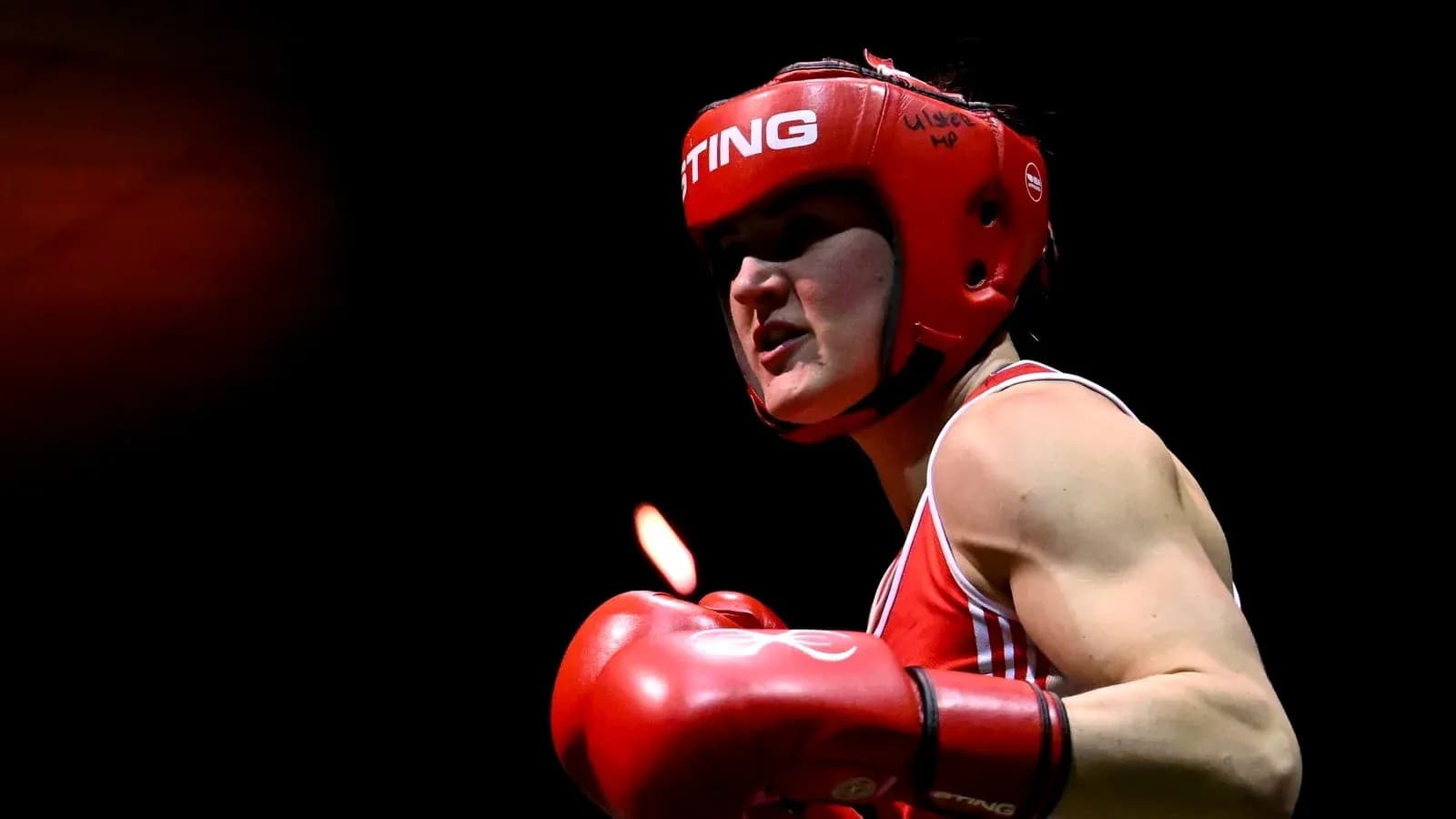 Boxeuse en action avec casque et gants rouges Boxeuse en action avec casque et gants rouges