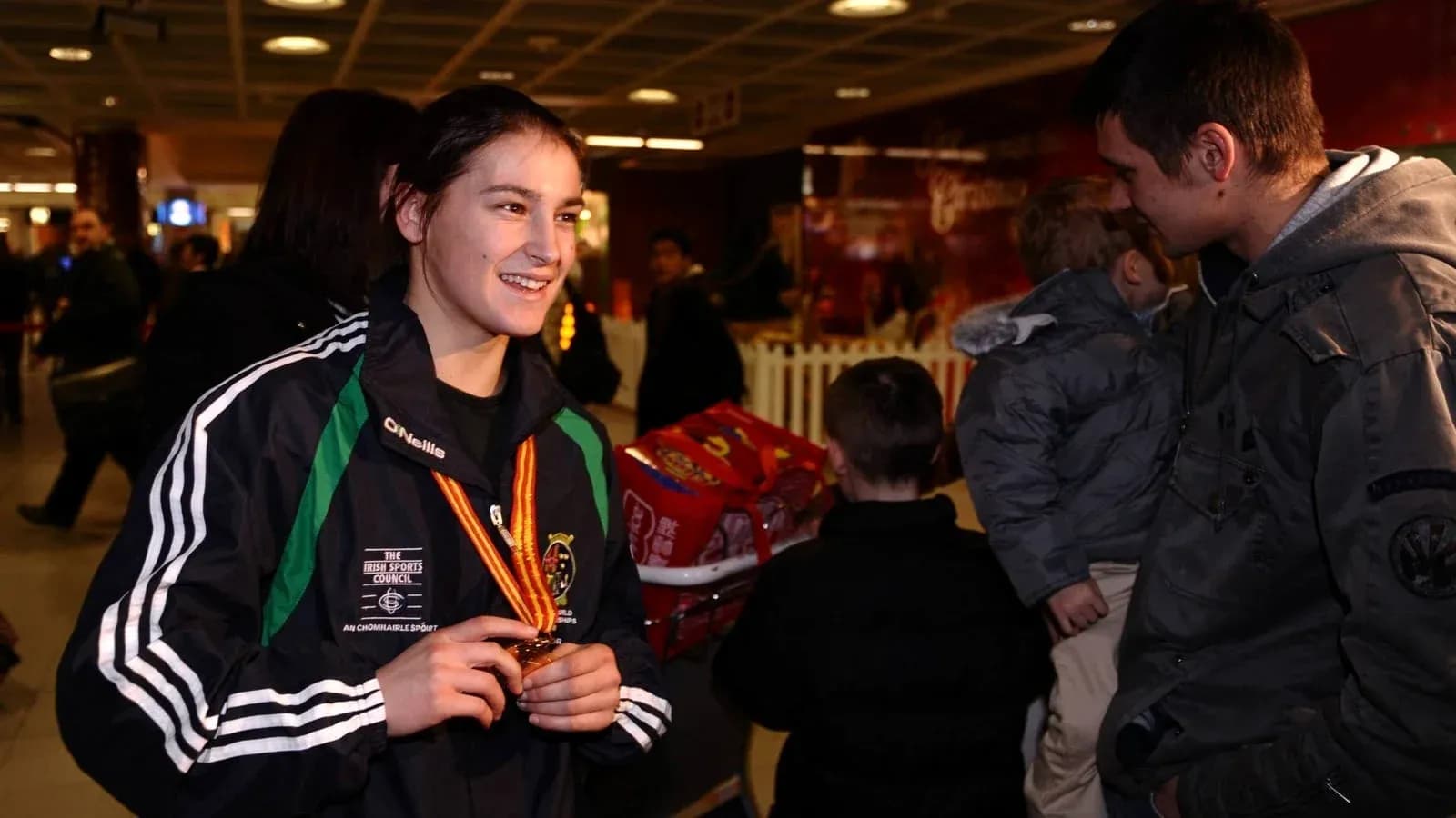 Athlete with medal chatting in an airport Athlete with medal chatting in an airport