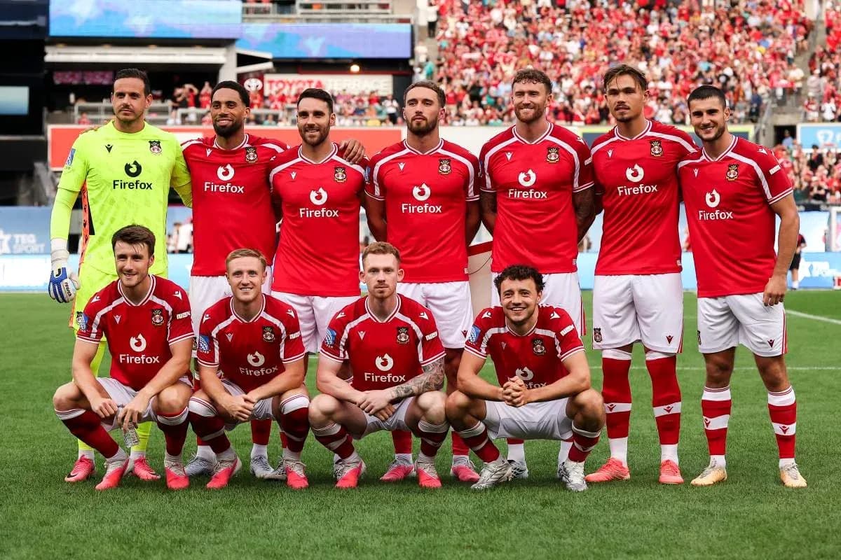 Équipe de football posant en tenue rouge sur le terrain Équipe de football posant en tenue rouge sur le terrain