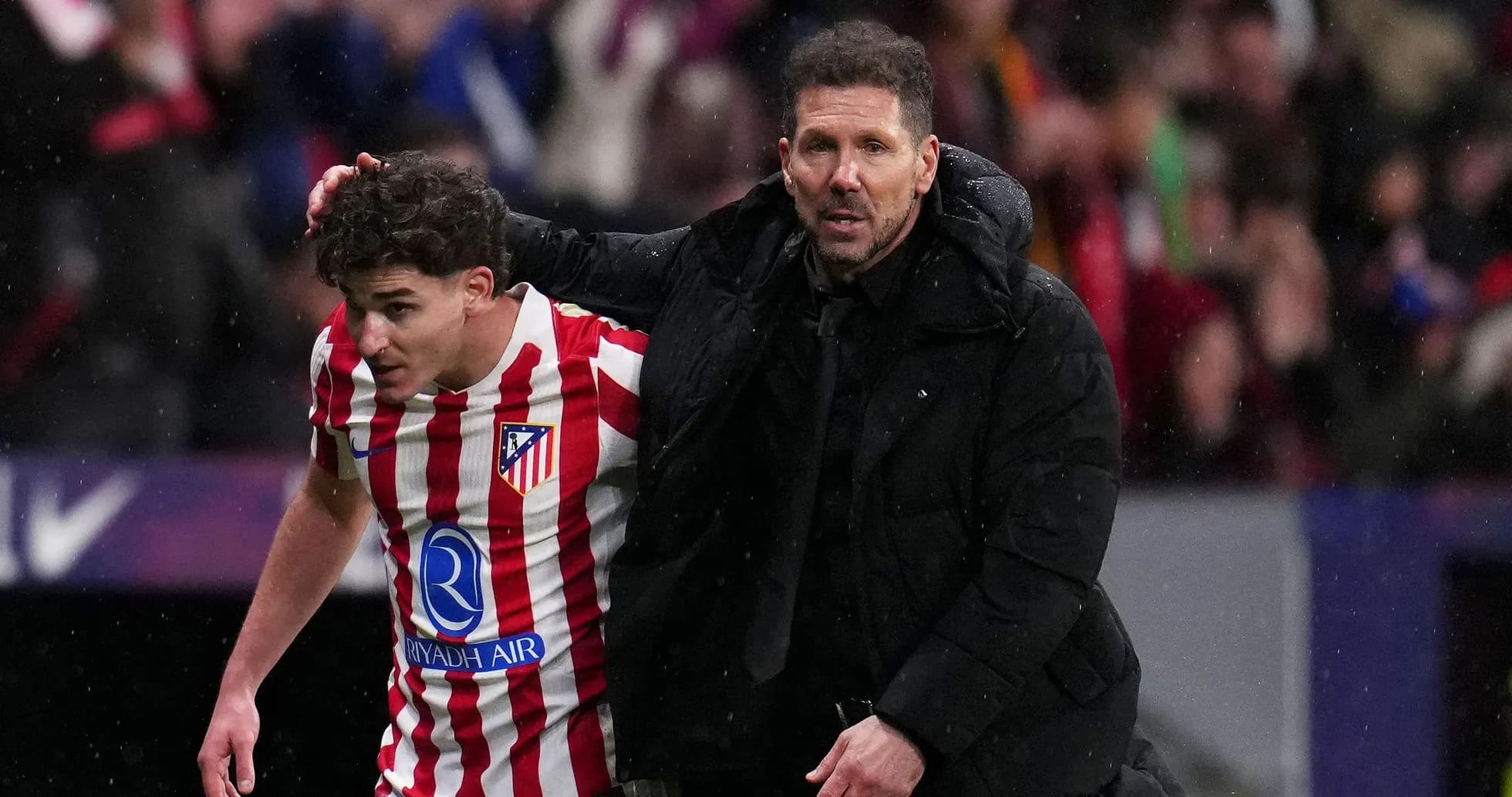 Joueur d'Atletico Madrid aidé par l'entraîneur Joueur d'Atletico Madrid aidé par l'entraîneur