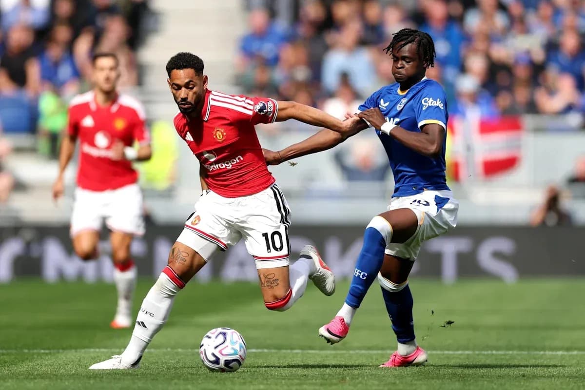 Joueur de Manchester United dribblant un adversaire d'Everton Joueur de Manchester United dribblant un adversaire d'Everton