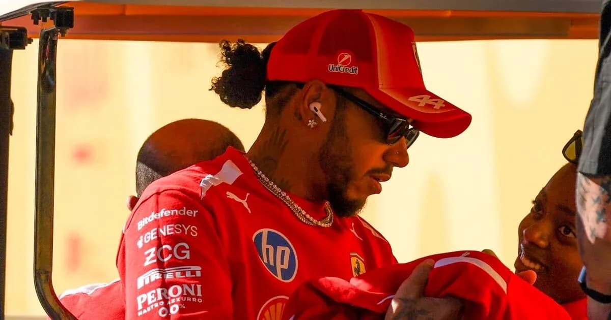 Pilote en combinaison Ferrari interagissant avec une personne Pilote en combinaison Ferrari interagissant avec une personne
