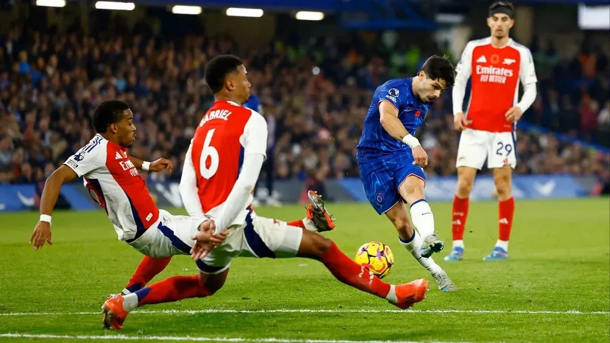 Joueur de Chelsea tirant au but entre deux défenseurs d'Arsenal Joueur de Chelsea tirant au but entre deux défenseurs d'Arsenal