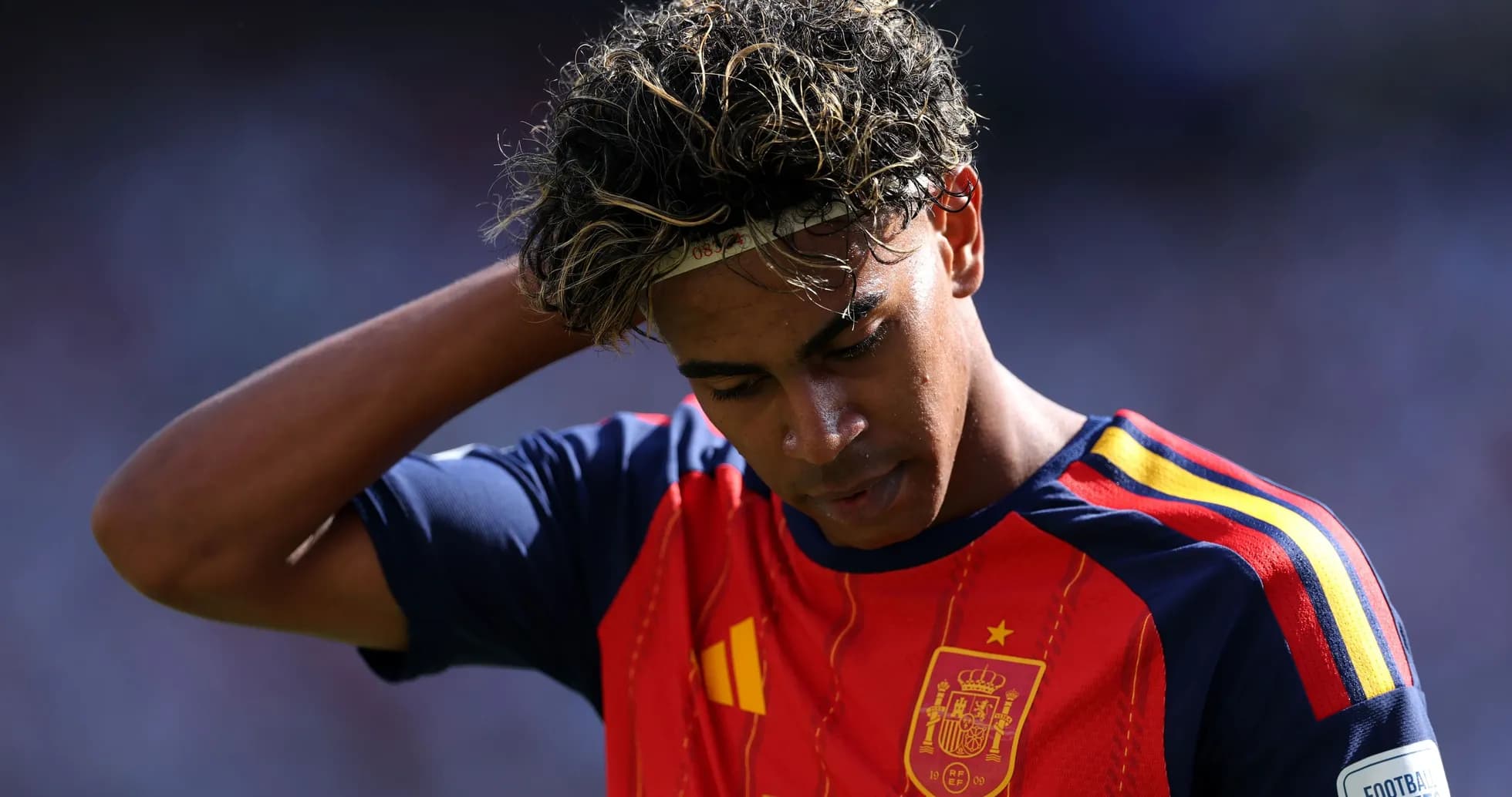 Joueur en maillot de l'Espagne touchant ses cheveux Joueur en maillot de l'Espagne touchant ses cheveux