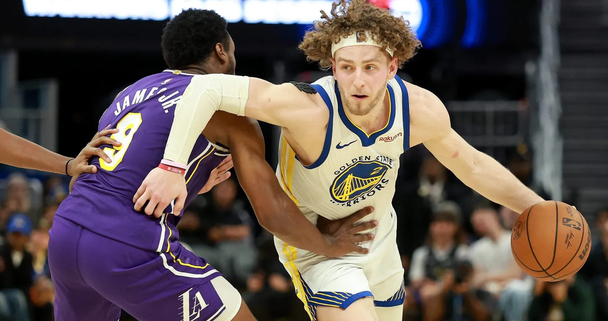 Joueur des Warriors dribblant sous la pression d'un adversaire Joueur des Warriors dribblant sous la pression d'un adversaire