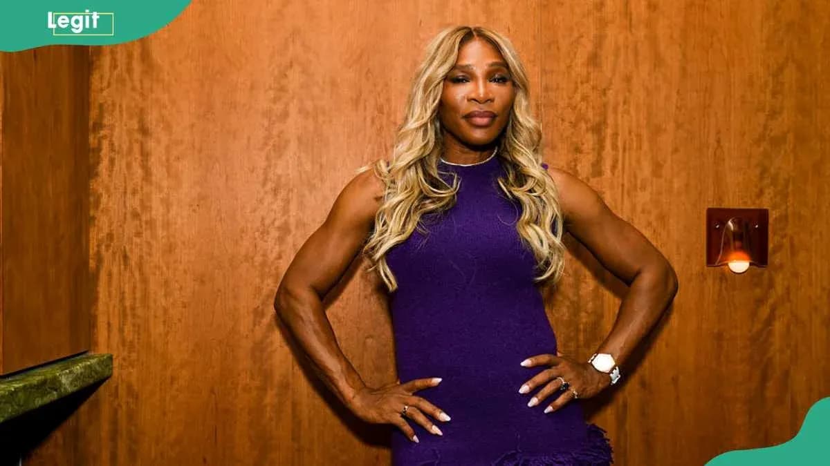 Femme musclée posant avec confiance devant un mur Femme musclée posant avec confiance devant un mur