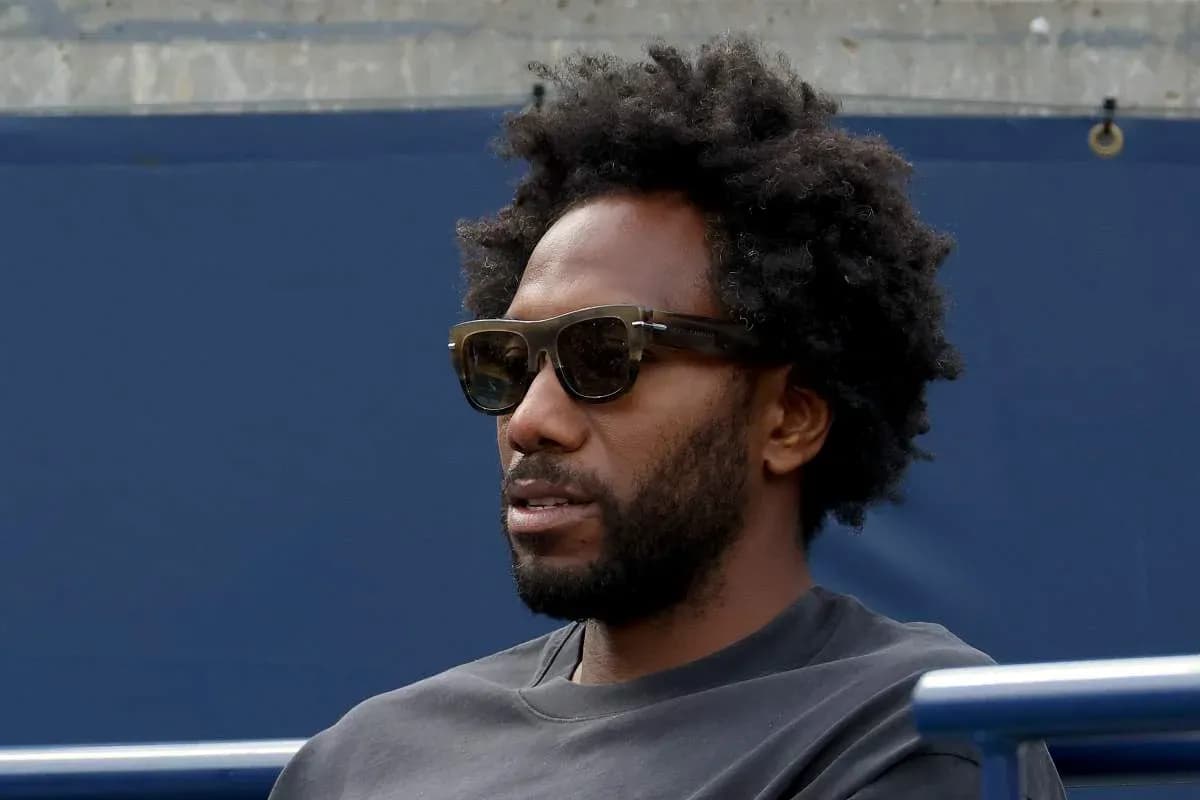 Homme portant des lunettes de soleil, assis tranquillement Homme portant des lunettes de soleil, assis tranquillement