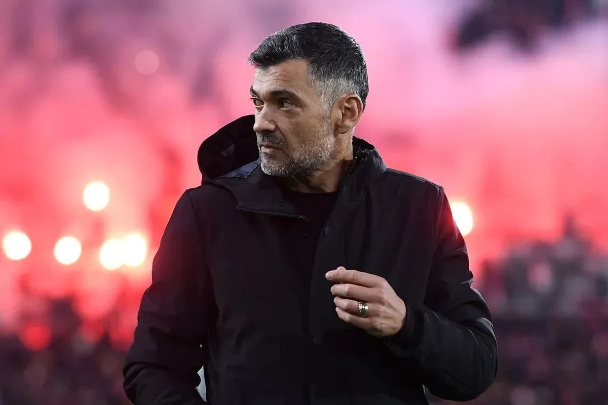 Entraîneur observant le match avec fumigènes en arrière-plan Entraîneur observant le match avec fumigènes en arrière-plan