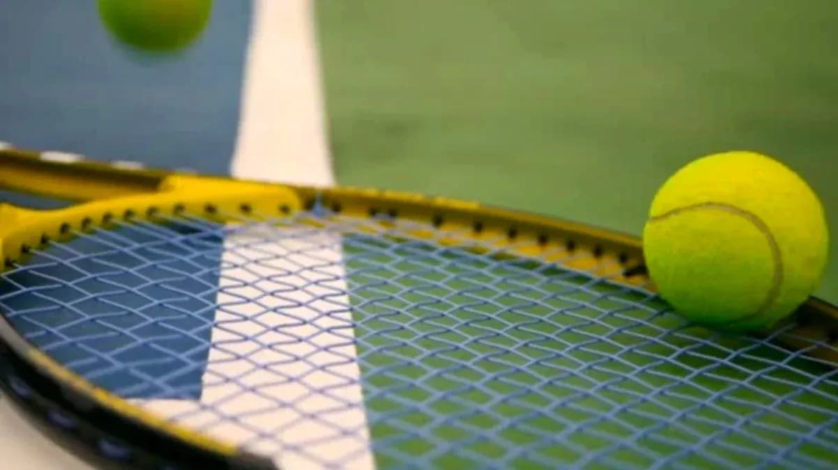 Balle de tennis sur une raquette sur court Balle de tennis sur une raquette sur court