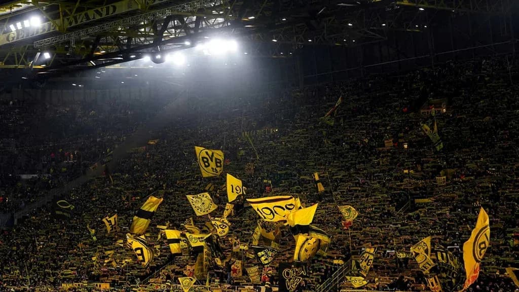 Supporters waving flags in Borussia Dortmund stadium Supporters waving flags in Borussia Dortmund stadium
